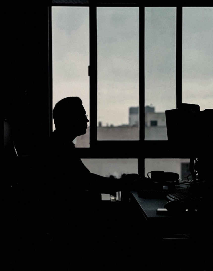 A man working at his desk, a silhouette against a window. A message from Snags in Microsoft Teams to Roger: a contract approval, waiting 6 days.